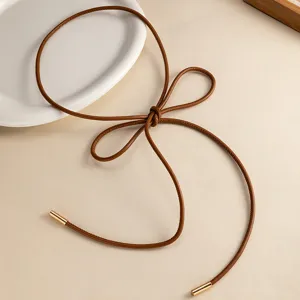 Cinturón fino de cuero marrón minimalista, detalle de lazo accesorio para vestido