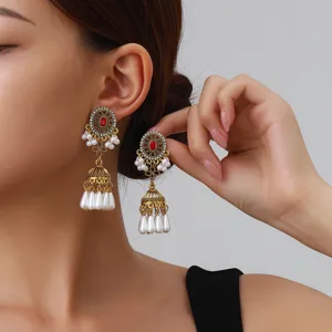 Detailed shot of vintage ethnic style long jhumka earrings with pearls and red center stones.