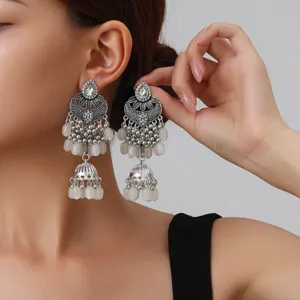 Vue détaillée de boucles d'oreilles jhumka argentées rétro ethniques avec gravure et perles.