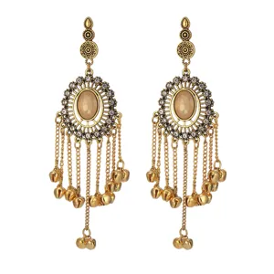 Detailed view of bohemian Indian style long tassel bell earrings with rhinestones and vintage gold finish.