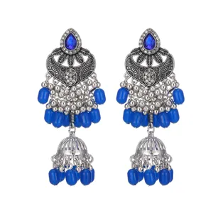 Gros plan détail de boucles d'oreilles ethniques bohèmes en argent avec perles et pierre bleues.