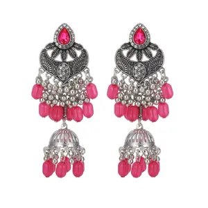 Gros plan de boucles d'oreilles style ethnique, argent vieilli, perles roses et strass.