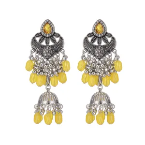Gros plan détaillé de boucles d'oreilles pendantes style ethnique avec perles jaunes.