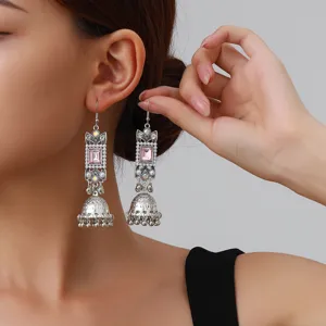 Close-up detail of retro silver square rhinestone jhumka earrings with ethnic design.