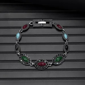 Detailed shot of vintage multi-stone bracelet showing intricate retro metalwork and vivid gems.