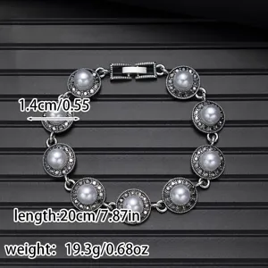 Vintage style silver bracelet detail featuring round pearl design and detailed metalwork.