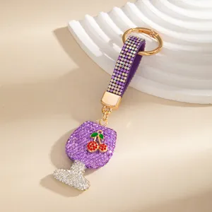 Primo piano dettagliato del portachiavi a forma di bicchiere di vino in strass con cristalli viola.