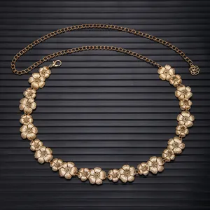 Gold metal chain belt with floral charms, detailed view showing elegant design for dresses.