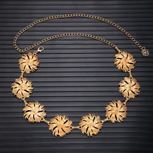 Detailed view of a vintage gold metal floral waist chain belt with delicate flower charms for dresses.