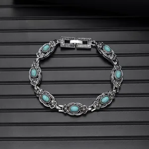 Close-up of vintage turquoise silver bracelet, intricate carved details, ethnic jewelry style.