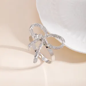 Anello portatovagliolo in metallo argentato con fiocco, elegante dettaglio per tavola e hotel.