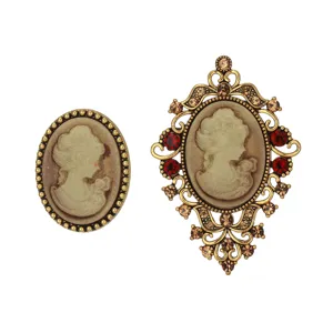 Vintage cameo brooch detail, ornate gold-tone metal frame with red and amber rhinestones.