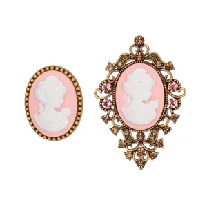 Vintage cameo brooch set featuring elegant pink portrait relief and ornate rhinestone details.