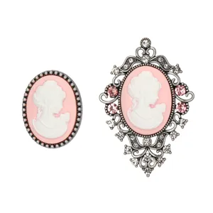 Detailed view of vintage cameo brooch set featuring classic relief portrait and pink rhinestones.