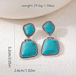 Close-up detail of vintage turquoise drop earrings showing intricate silver rope texture.