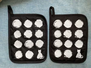 Black and white cotton twill pot holders featuring stylish dot pattern and cute cat print.
