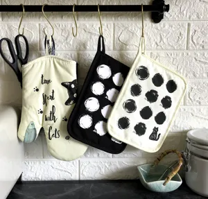 Black and white cotton cat pattern oven mitt and polka dot hot pads kitchen set for cooking.