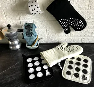 Black and white polka dot cotton oven mitts and pot holders set with cute cat design.