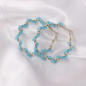 Detail view of trendy blue crystal wrapped gold hoop earrings for stylish women daily wear.