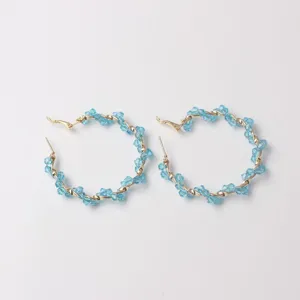 Detailed view of stylish light blue crystal wrapped hoop earrings, elegant gold tone metal design.