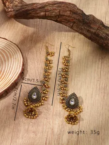 Vue detaillee de boucles d'oreilles a pampilles et cloches strass style indien vintage.