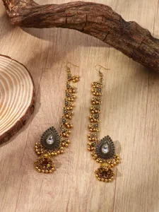 Vue détaillée de longues boucles d'oreilles jhumka et chaînes de cheveux strass style ethnique indien.