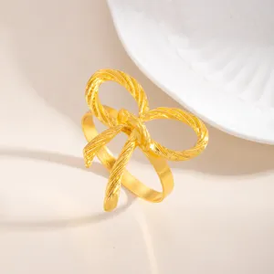 Anello portatovagliolo con fiocco in lega dorata per decorazione tavola dettaglio.