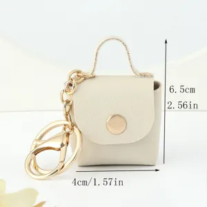 Dettaglio del portachiavi mini borsa in pelle con rifiniture in metallo dorato di alta qualità.