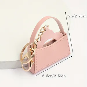 Gedetailleerd overzicht van de roze lederen mini handtas sleutelhanger met goud.