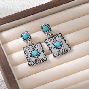 Detailed shot of retro silver bohemian turquoise drop earrings with geometric patterns.