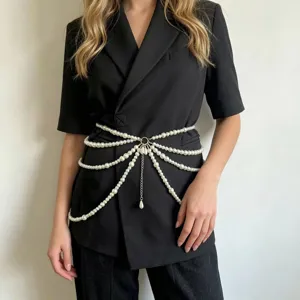 Detail shot of multi-layer pearl waist chain detail, elegant tassel design, fashion accessory.