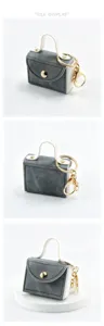 Mini denim stijl handtas sleutelhanger detail met gouden hardware en fijne stiksels.