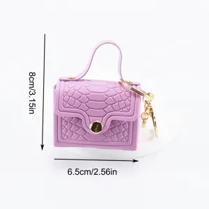 Simpatico mini borsetta portachiavi rosa con trama coccodrillo e finiture in metallo.