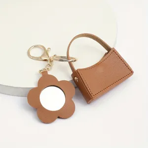 Stijlvolle bruine lederen mini tas sleutelhanger met bloem spiegel, creatief cadeau.