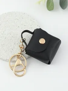 Primo piano dettagliato di un simpatico portachiavi borsa in pelle nera con dettagli dorati.