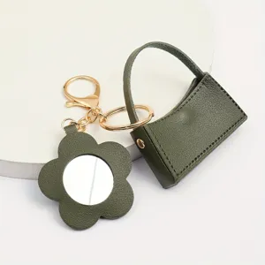 Groene lederen mini handtas sleutelhanger met bloem spiegel hanger en gouden metaal.