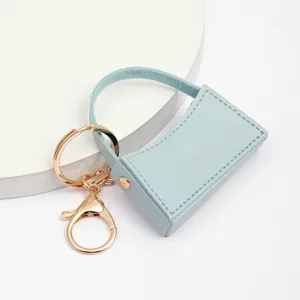 Joli mini porte-clefs sac à main en cuir PU avec accessoires dorés vue de détail.