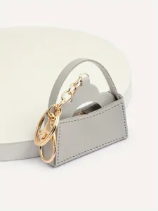 Mini lederen handtas sleutelhanger, grijs tasje bedel met gouden ketting en hardware.