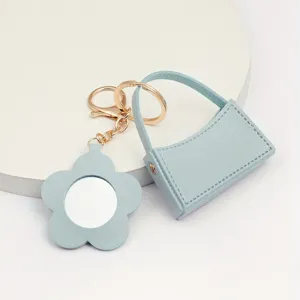 Leuke lichtblauwe lederen mini handtas sleutelhanger met bijpassende bloem spiegel hanger.