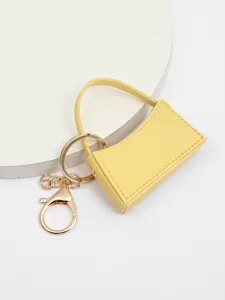 Vue détaillée du mini porte-clés sac en cuir PU, charmant pendentif de sac jaune vif.