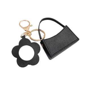 Zwarte lederen mini hobo tas sleutelhanger met bloem spiegel en gouden accessoires.