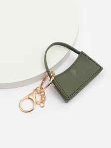 Gros plan détaillé du porte-clés mini sac à main en cuir PU vert foncé et doré.