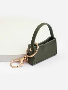 Gros plan détaillé d'un porte-clés mini sac à main élégant en cuir PU vert foncé.