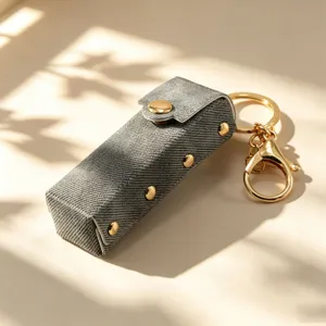 Retro denim leer lipstick hoesje sleutelhanger met gouden klinknagels en metalen ring.