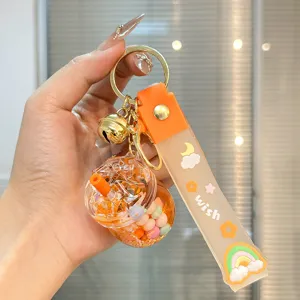 Nahaufnahme des süßen Bubble-Tea-Flüssig-Treibsand-Schlüsselanhängers mit bunten Elementen.