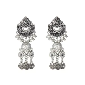 Vue détaillée de boucles d'oreilles jhumka argentées vintage aux motifs sculptés et pampilles.