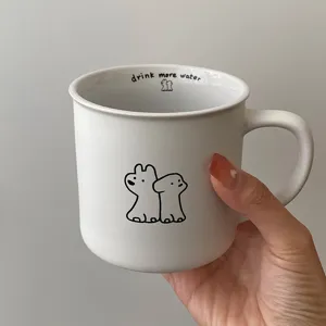 Ceramic coffee mug detail showing minimalist cute dog illustration and interior text design.