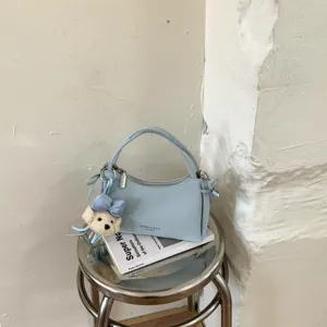 Light blue leather women handbag shoulder bag with cute plush puppy dog charm detail.