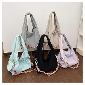 Dettaglio ravvicinato di borse shopper in tela morbida con bellissime trecce di corda colorate.