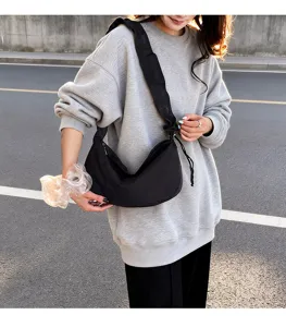 Detail shot of black casual slouchy shoulder crossbody bag, lightweight daily commuting style.